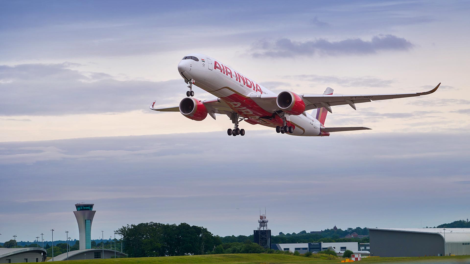 An Air India aircraft taking off against a cloudy sky