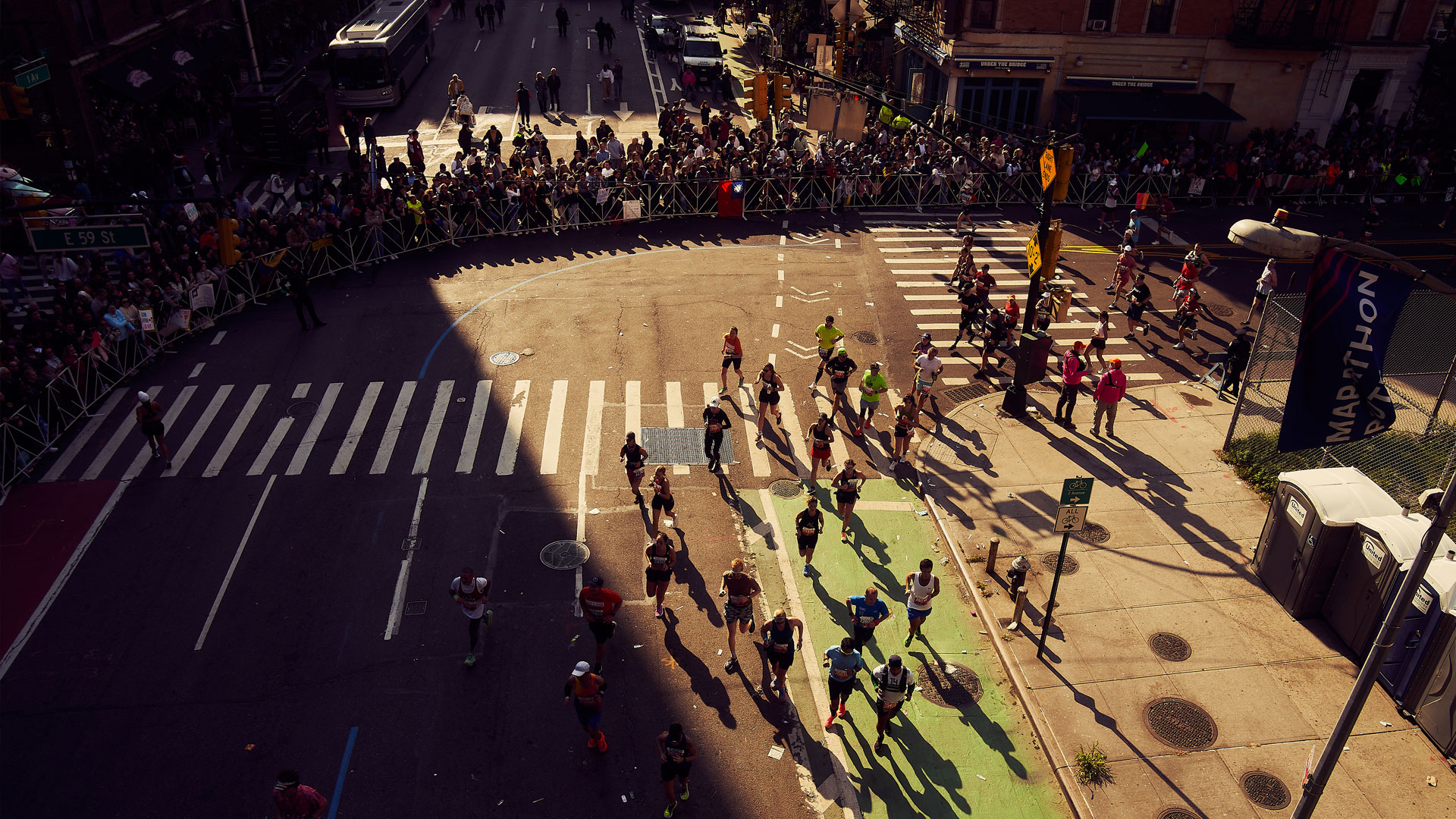 Runners through a sunlit avenue in downtown Manhattan